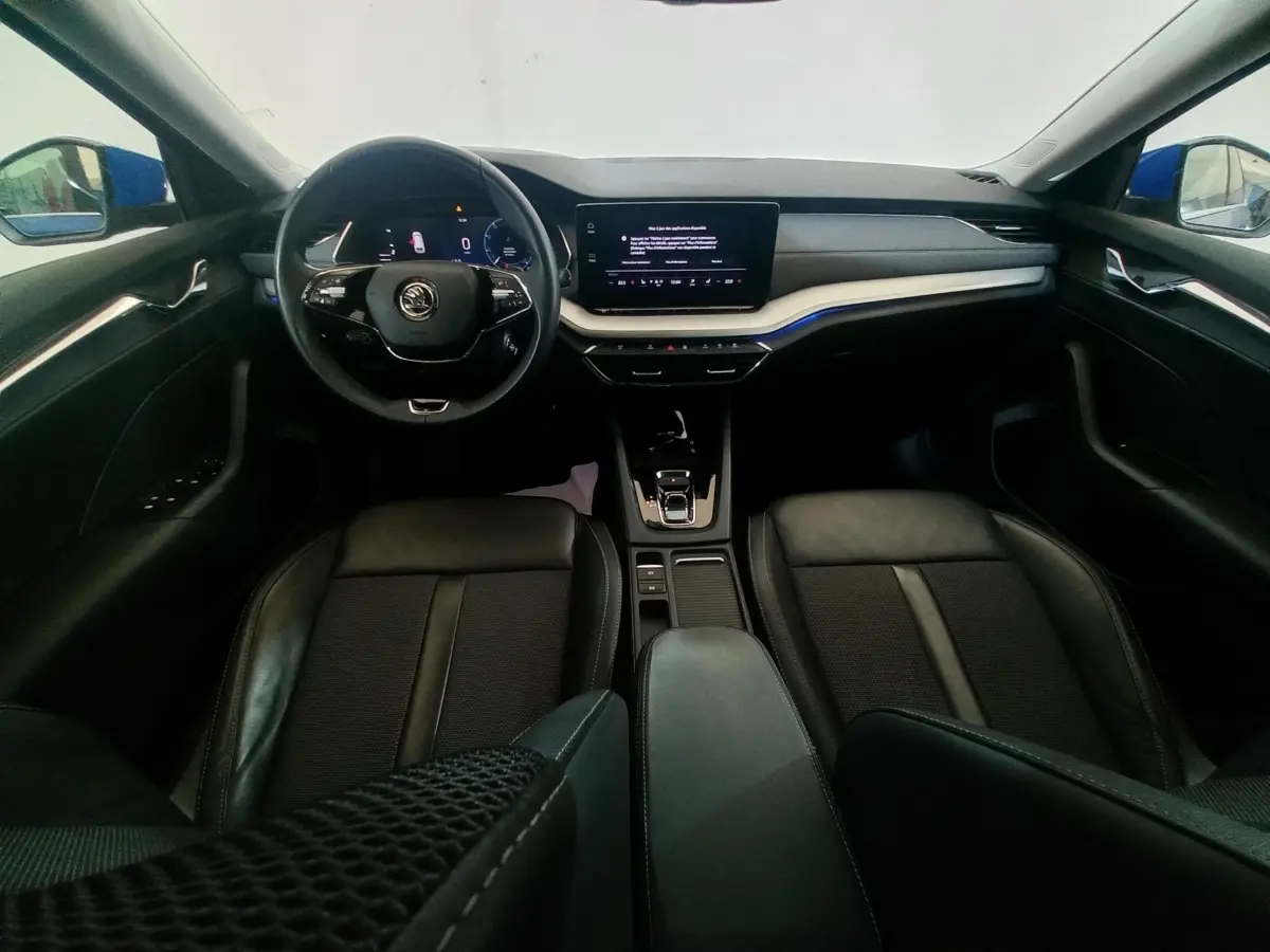 Vue intérieure avant de la Skoda Octavia 1.5 TSI mHEV 2022, tableau de bord noir avec écran tactile central et volant multifonctions.