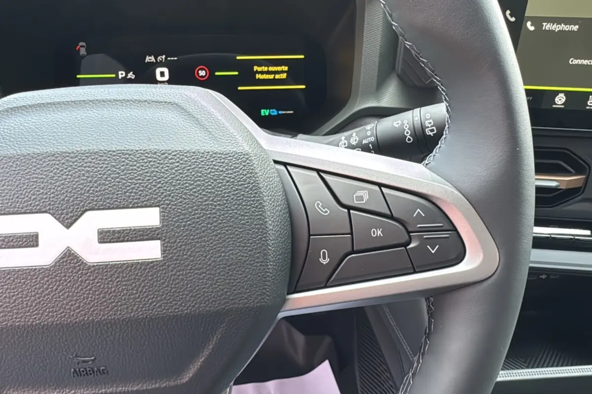 Gros plan sur le volant cuir multifonction du Dacia Bigster 2026 avec tableau de bord digital et commandes au volant visibles.