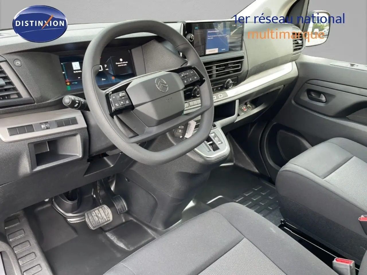 Vue intérieure côté conducteur du Citroën Jumpy cabine approfondie 2026, tableau de bord moderne et sièges tissu gris.