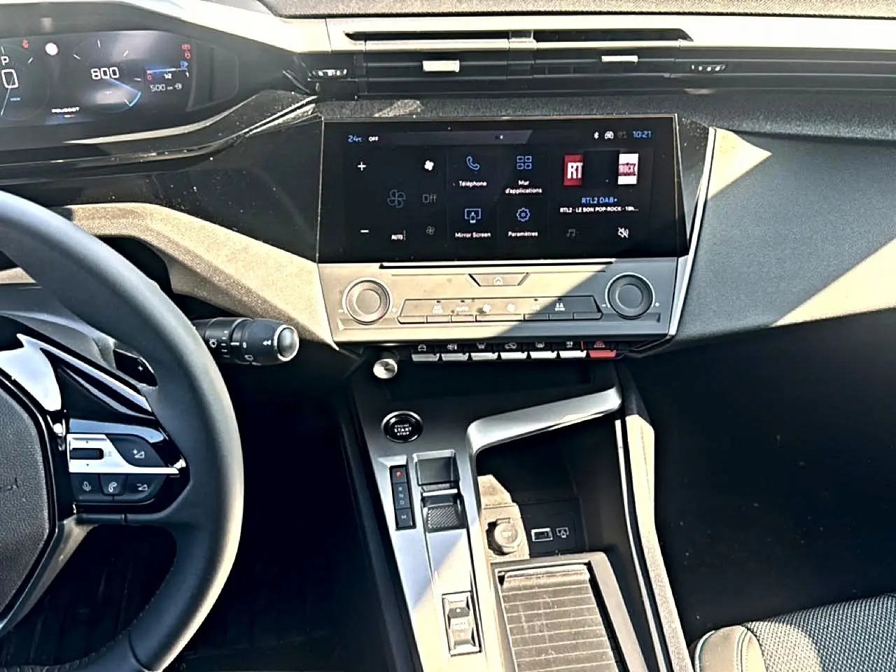 Vue intérieure de face du tableau de bord et console centrale de la Peugeot 308 gris artense avec écran tactile et volant multifonction.