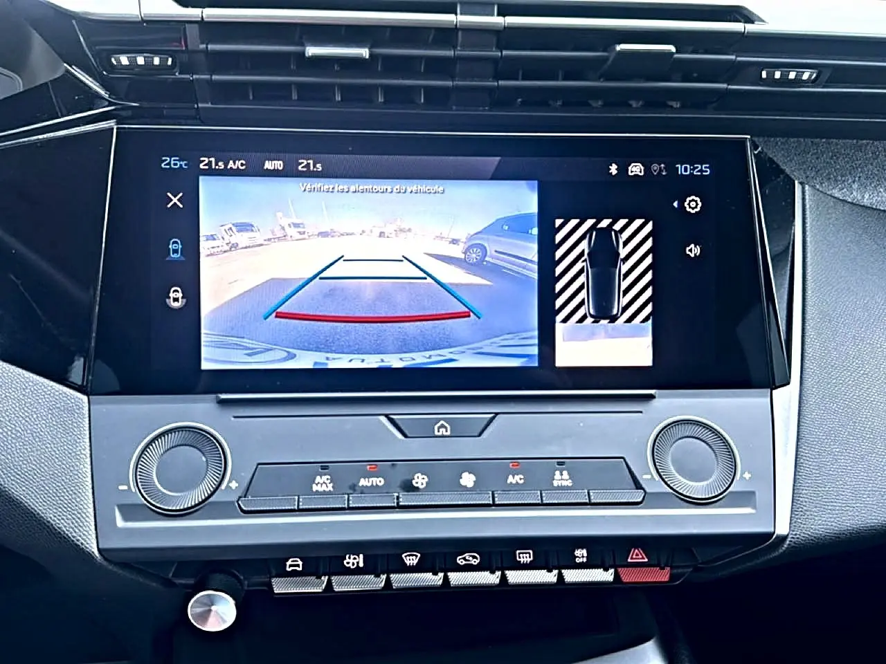 Vue rapprochée de l'écran tactile central affichant la caméra de recul dans l'habitacle d'une Peugeot 308 gris Artense.