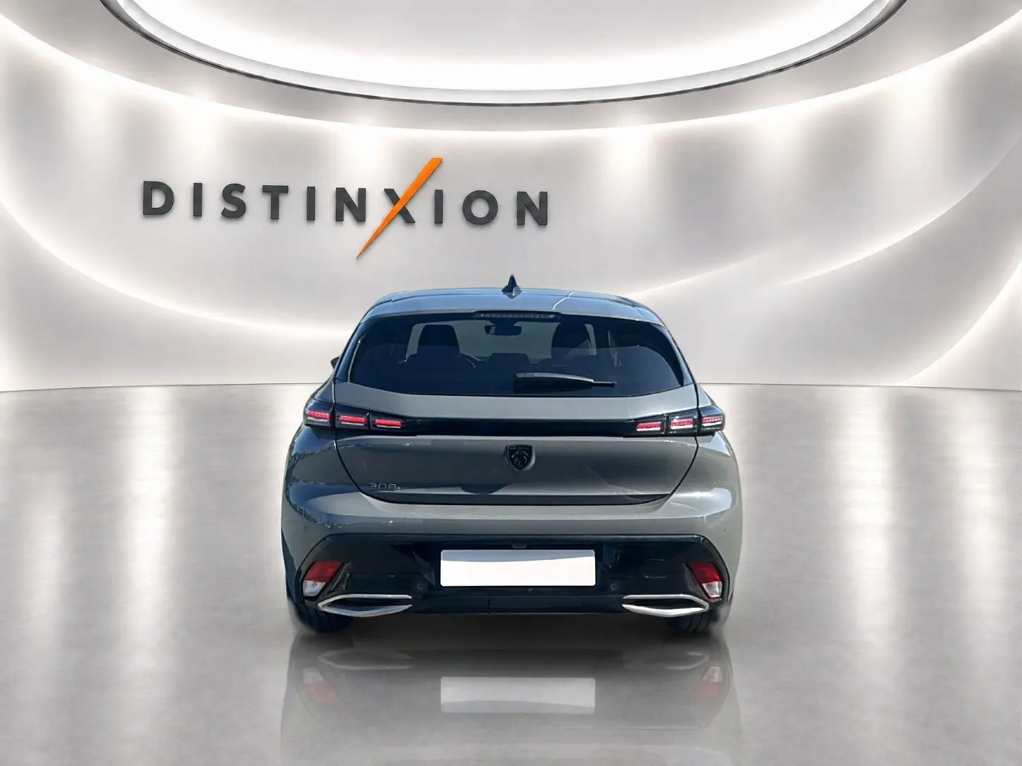 Vue arrière d'une Peugeot 308 1.5 BlueHDi 130 Allure gris Artense dans un showroom lumineux avec logo Distinxion en arrière-plan.