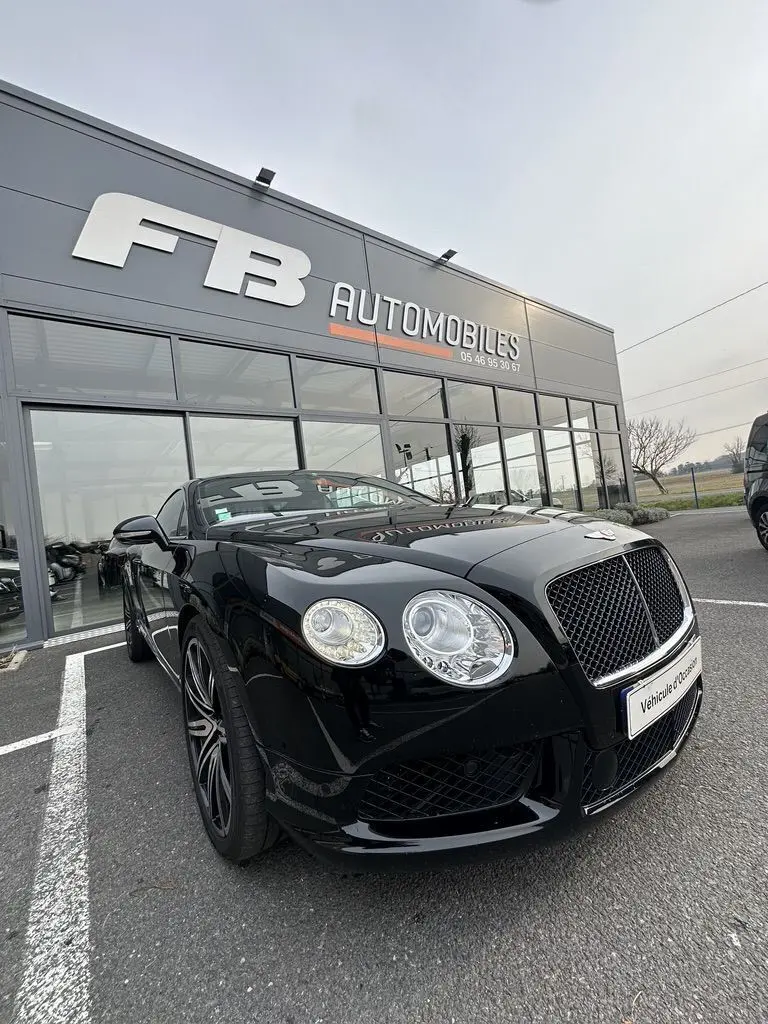 Bentley Continental GT 4.0 V8 Mulliner noire vue en 3/4 avant, avec calandre distinctive et phares ronds LED.