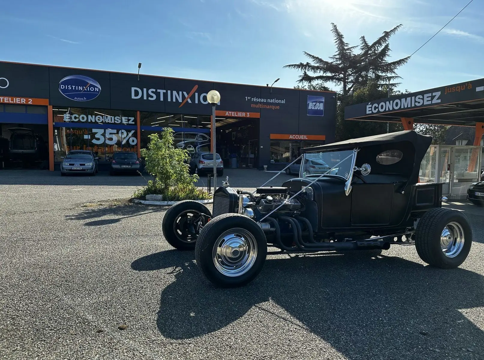 Vue 3/4 avant droite d'une Ford T Hot Rod V8 noire avec capote relevée et jantes chromées brillantes.