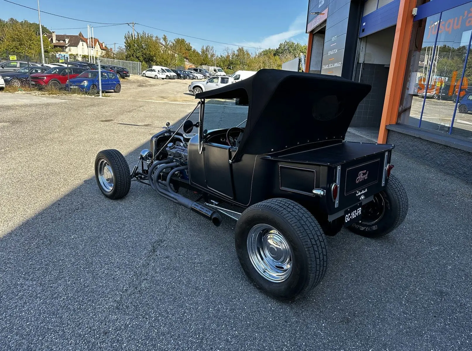 Ford T Hot Rod V8 noir vue 3/4 arrière droit avec capote relevée et jantes chromées brillantes