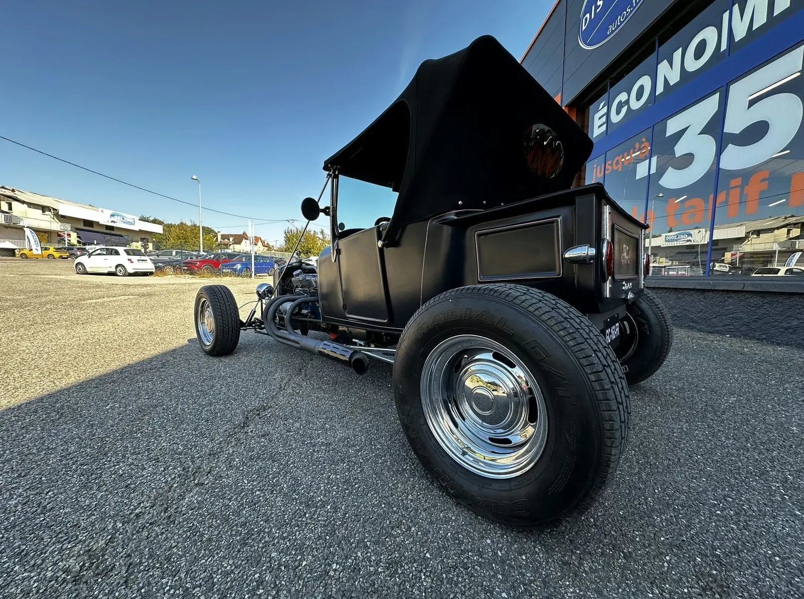 Vue 3/4 arrière droite du Ford T Hot Rod V8 noir décapotable, mettant en valeur ses roues chromées et son style vintage.