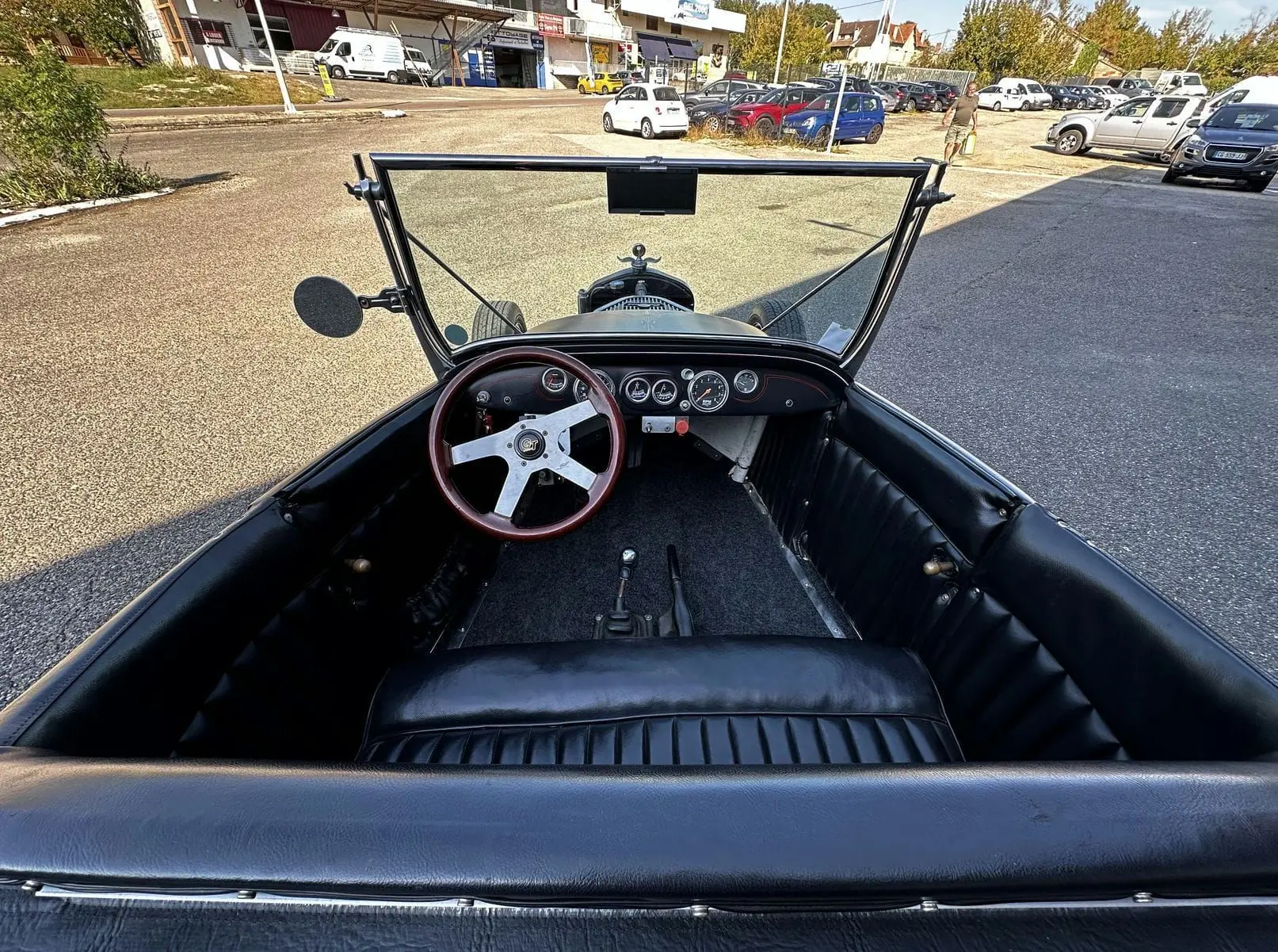 Vue intérieure avant du Ford T Hot Rod 1923 noir, volant bois GT et tableau de bord avec compteurs ronds.