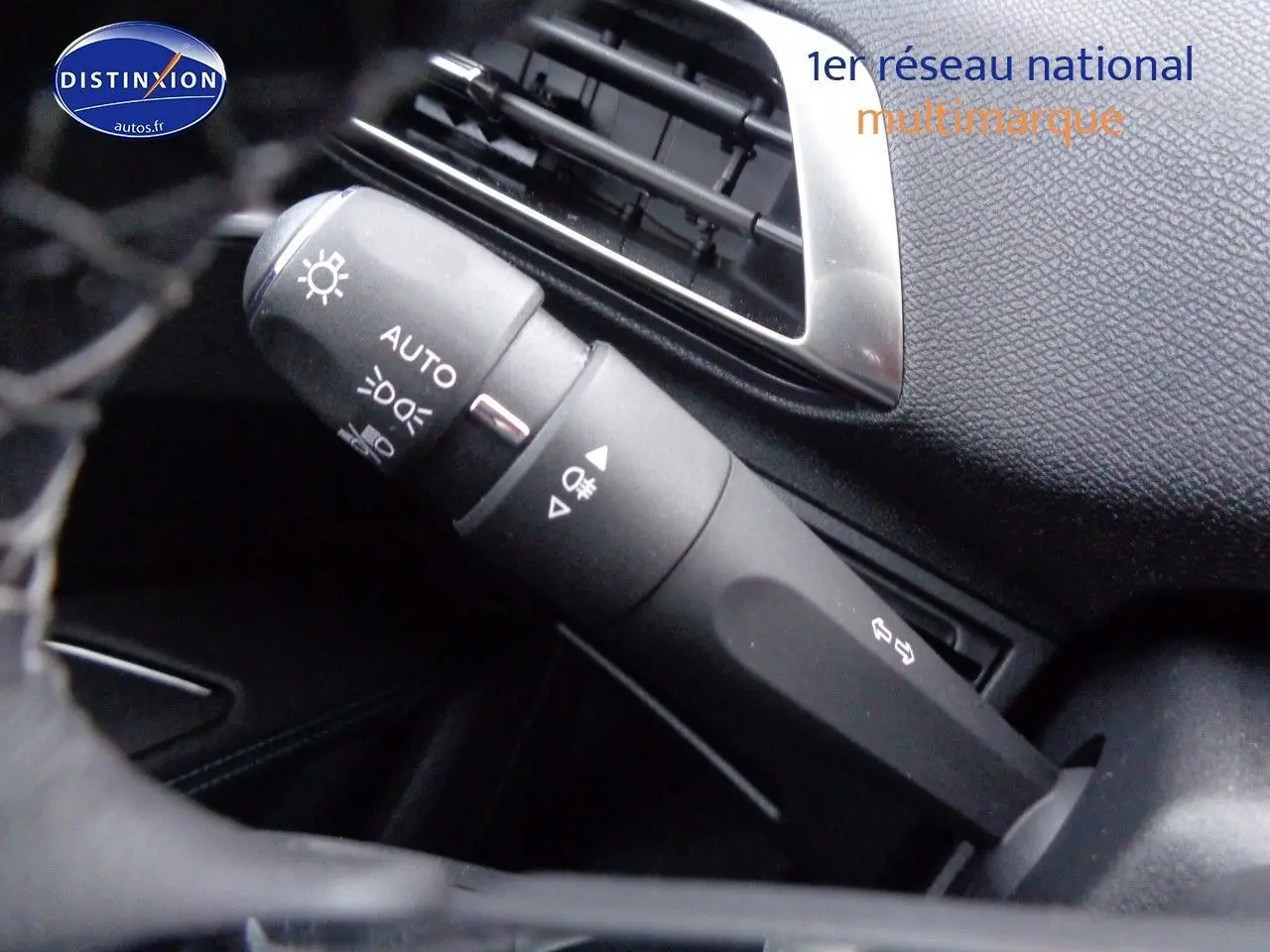 Gros plan sur la commande des phares et clignotants dans l'habitacle noir du Peugeot 3008 2023.