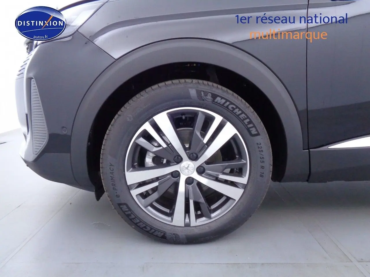 Gros plan sur la roue avant gauche du Peugeot 3008 noir métal 2023, mettant en valeur la jante aluminium bicolore et le pneu Michelin.