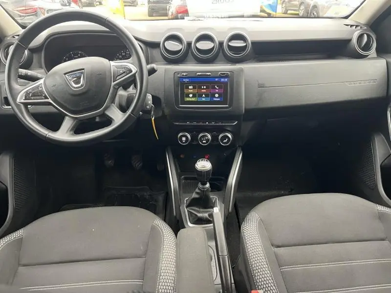 Vue intérieure du tableau de bord et volant multifonction du Dacia Duster 2019 avec sellerie noire et console centrale équipée d'un écran tactile.