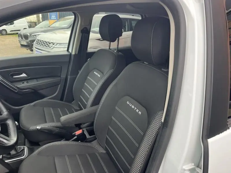 Vue intérieure des sièges avant noirs avec logo DUSTER du Dacia Duster blanc Glacier 2019, version Prestige.