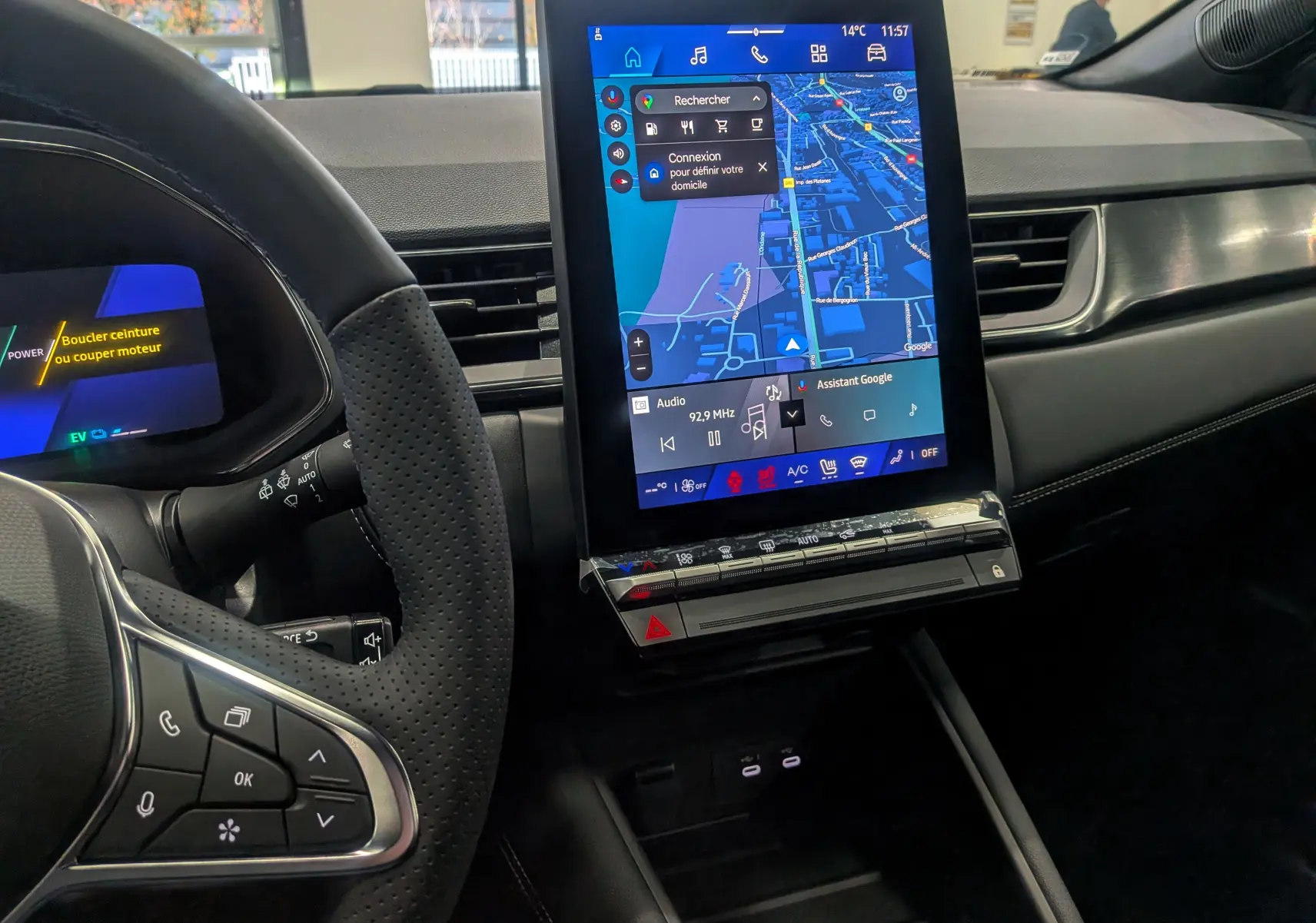 Vue intérieure du tableau de bord du Renault SYMBIOZ 2025, avec écran tactile vertical affichant la navigation et commandes au volant en cuir perforé noir.