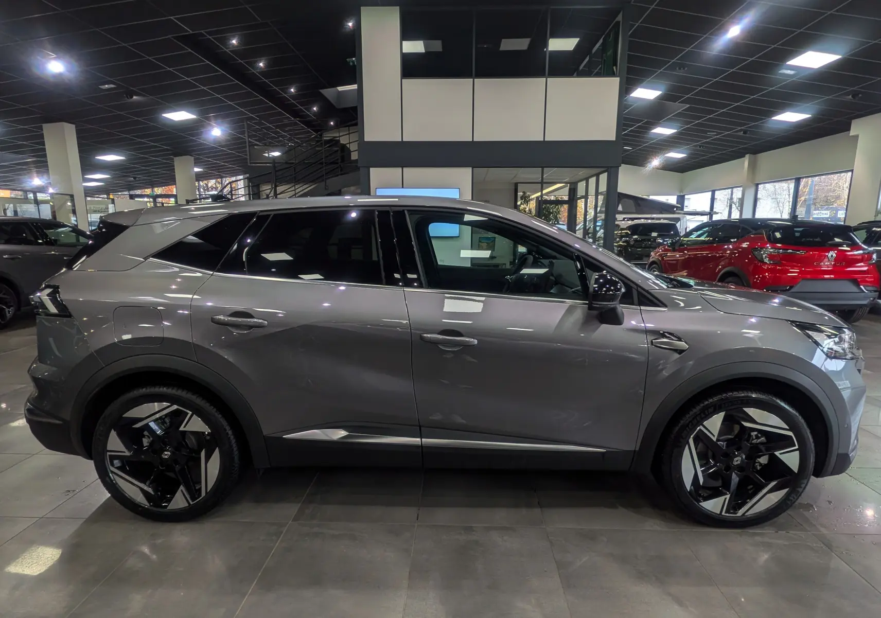 Vue latérale droite d'un Renault SYMBIOZ gris Cassiopé, soulignant ses jantes noires et argentées au design moderne.