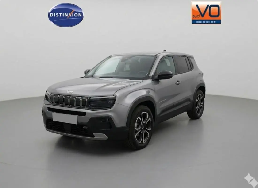 Jeep Avenger gris en 3/4 avant droit, avec jantes alliage 18 pouces et calandre noire distinctive.