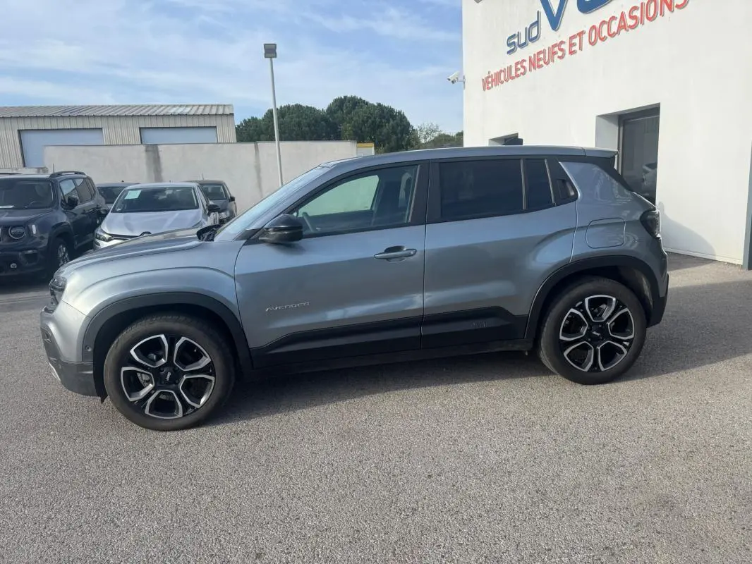 Vue de profil côté gauche d'un Jeep Avenger gris 2025 avec jantes alliage 18 pouces et rétroviseurs noirs.