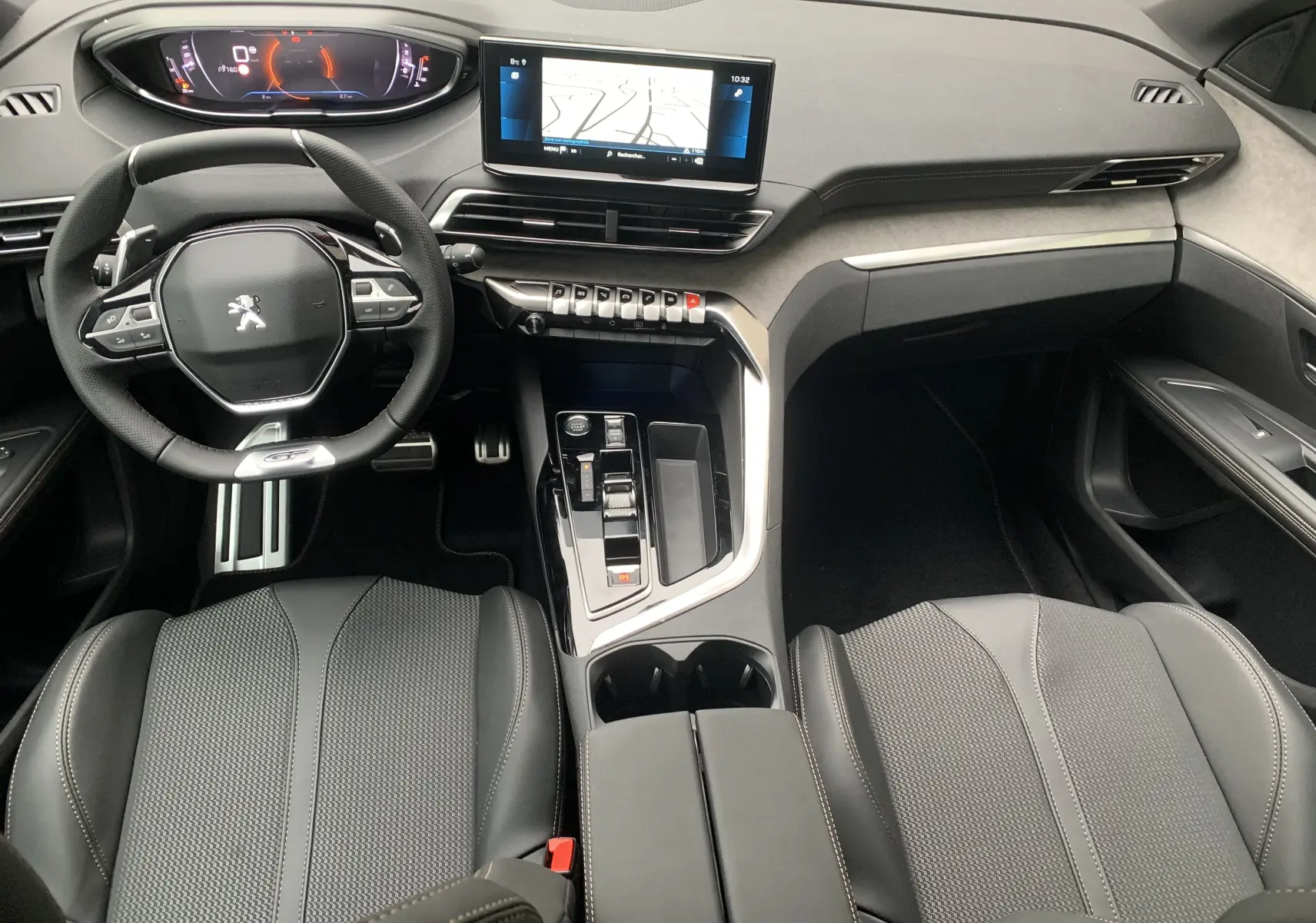 Vue intérieure avant du Peugeot 5008 GT 2024, tableau de bord moderne avec écran tactile et volant compact noir.