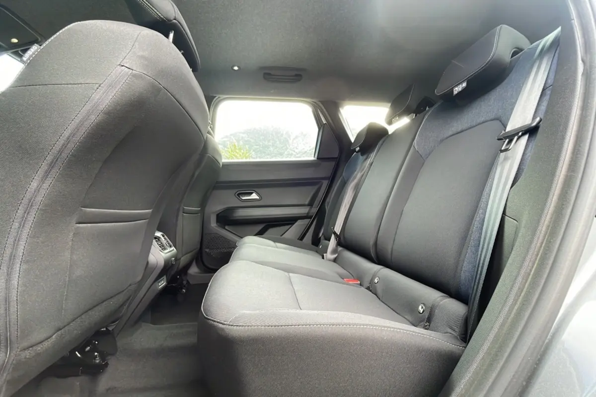 Vue intérieure arrière côté droit du Dacia Bigster 2025 gris schiste, banquette tissu avec appuie-têtes et ceintures visibles.