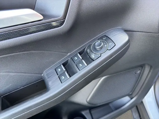 Gros plan sur la commande des vitres et rétroviseurs côté gauche d’un Ford Kuga gris 2024, finition ST-Line X.