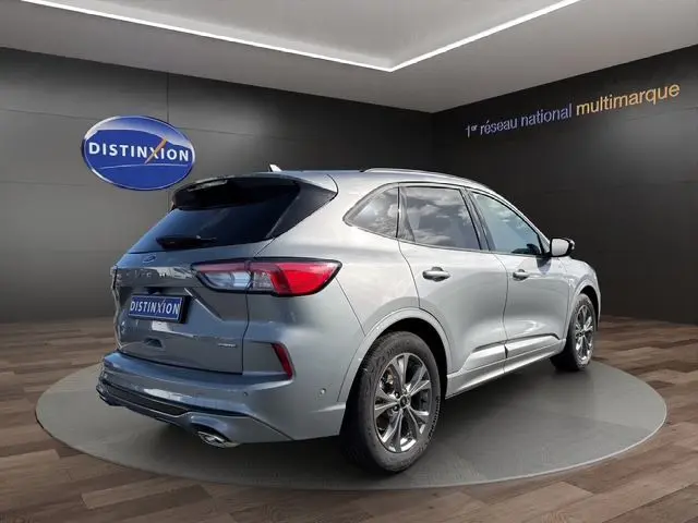 Vue 3/4 arrière droite d'un Ford Kuga gris 2024 finition ST-Line X avec détails sportifs et jantes alliage.