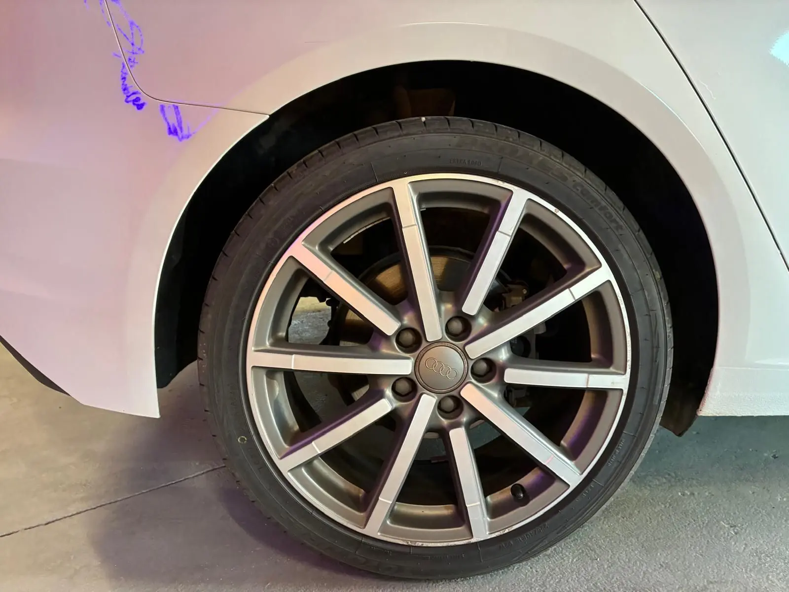Gros plan sur la roue arrière droite d'une Audi A3 Sportback blanche de 2019, mettant en valeur la jante alliage à dix branches.