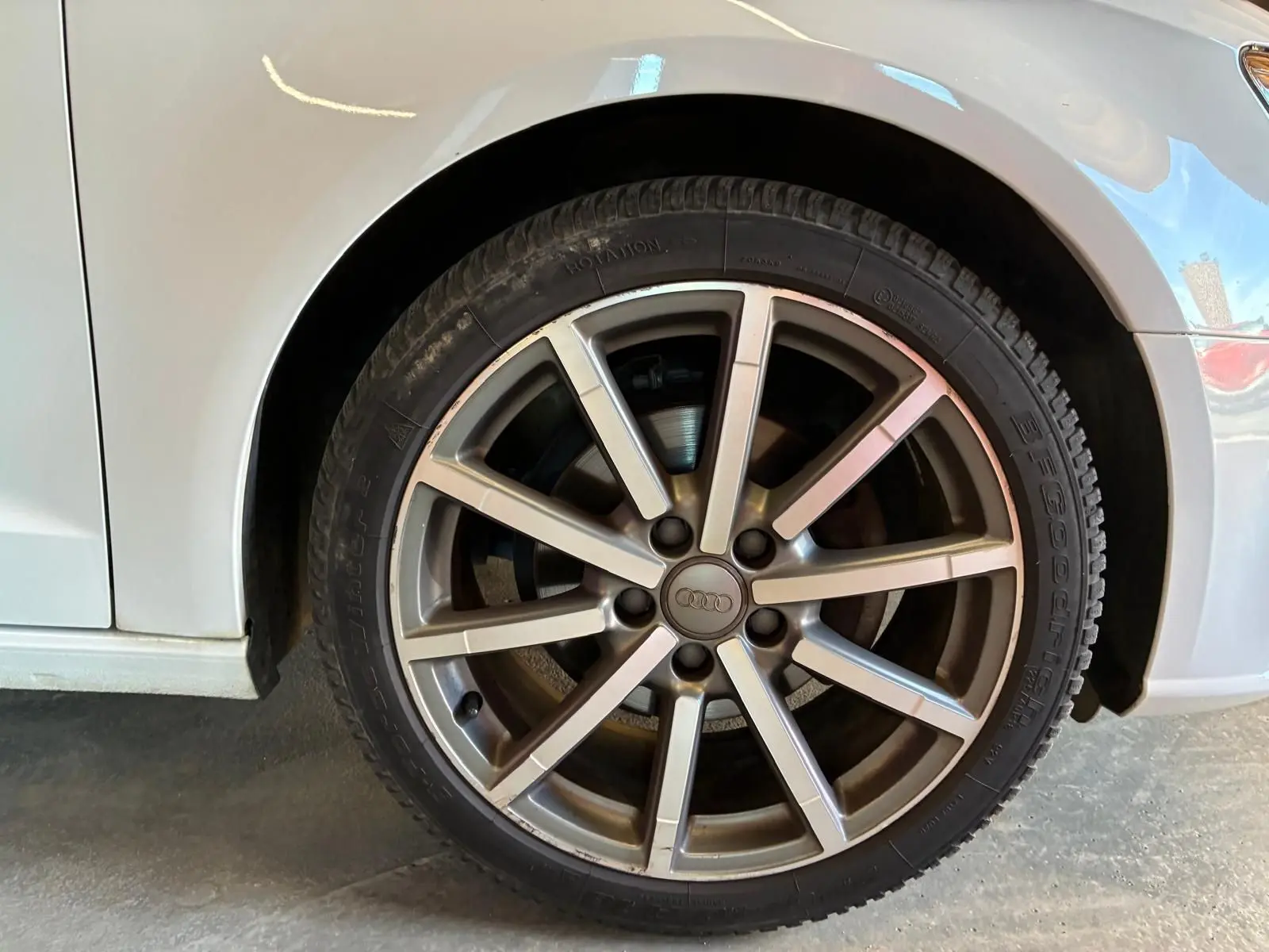Gros plan sur la roue avant droite d'une Audi A3 Sportback blanche, mettant en valeur la jante alliage à plusieurs branches.