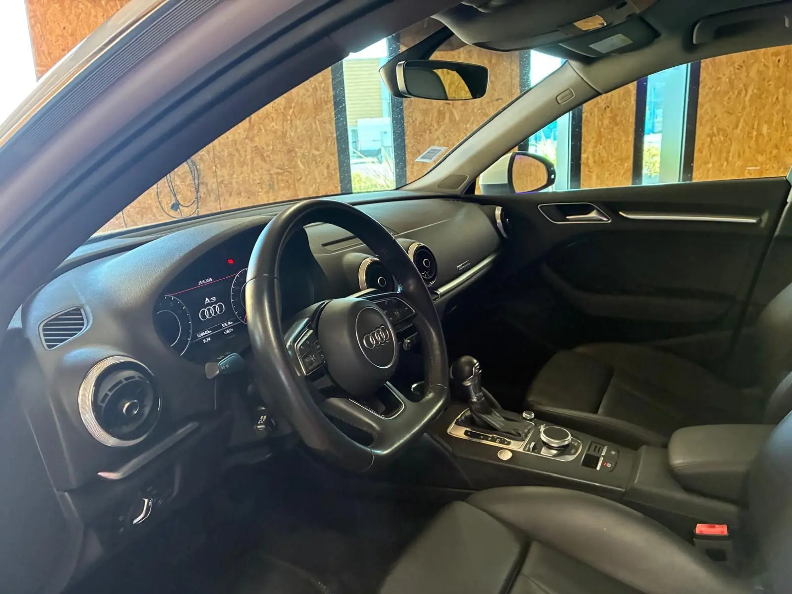 Vue intérieure côté conducteur de l'Audi A3 Sportback 2019 avec tableau de bord et sellerie cuir noire.