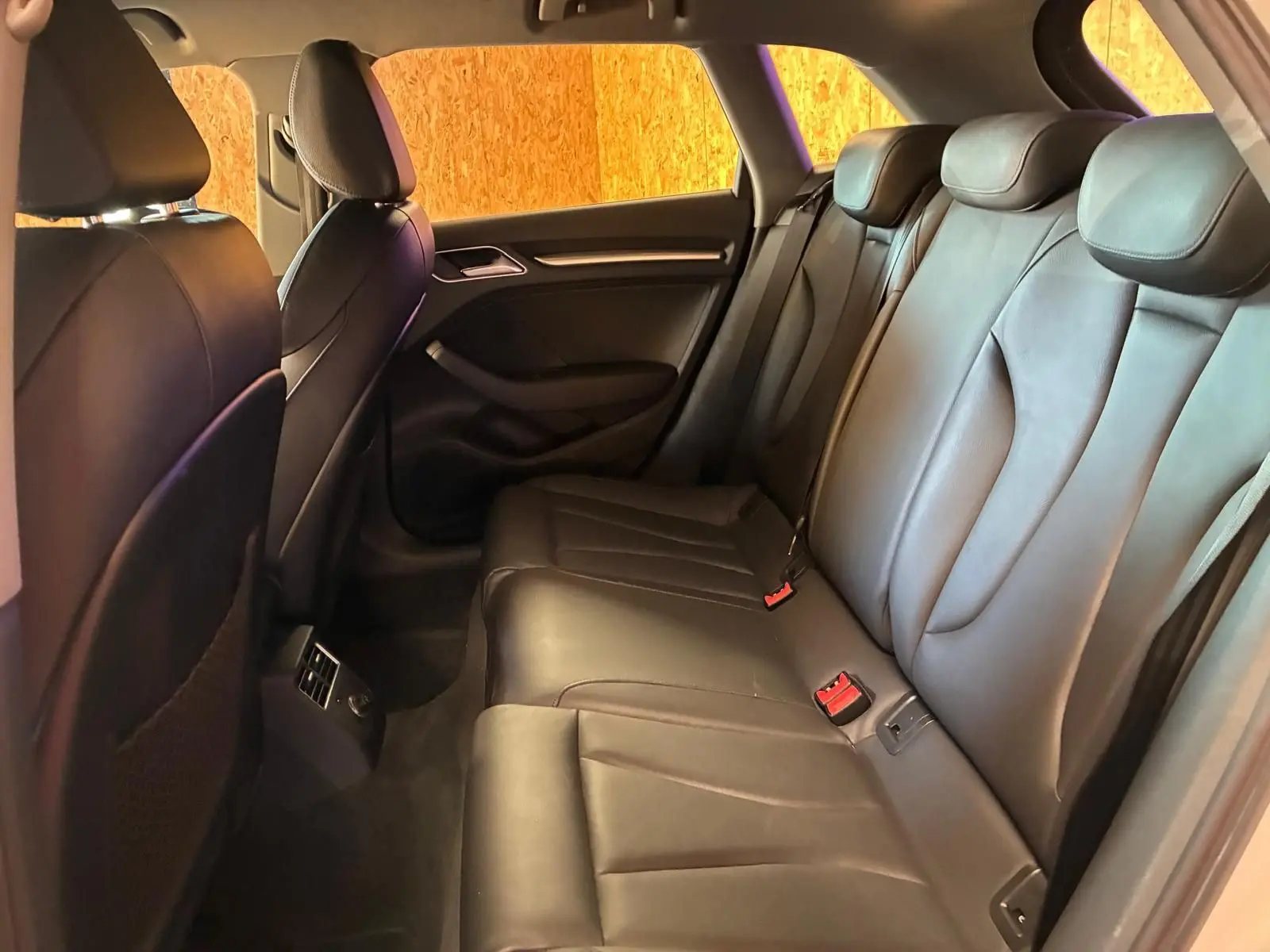 Vue intérieure côté droit des sièges arrière en cuir noir de l'Audi A3 Sportback 2019, ambiance élégante et soignée.