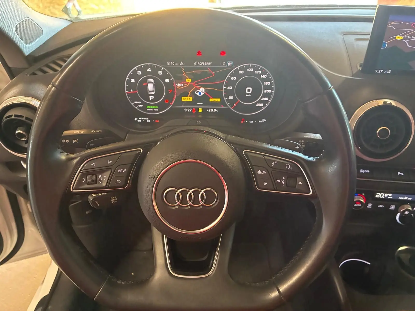 Vue rapprochée du volant noir de l'Audi A3 Sportback 2019 avec tableau de bord numérique et écran GPS visible.