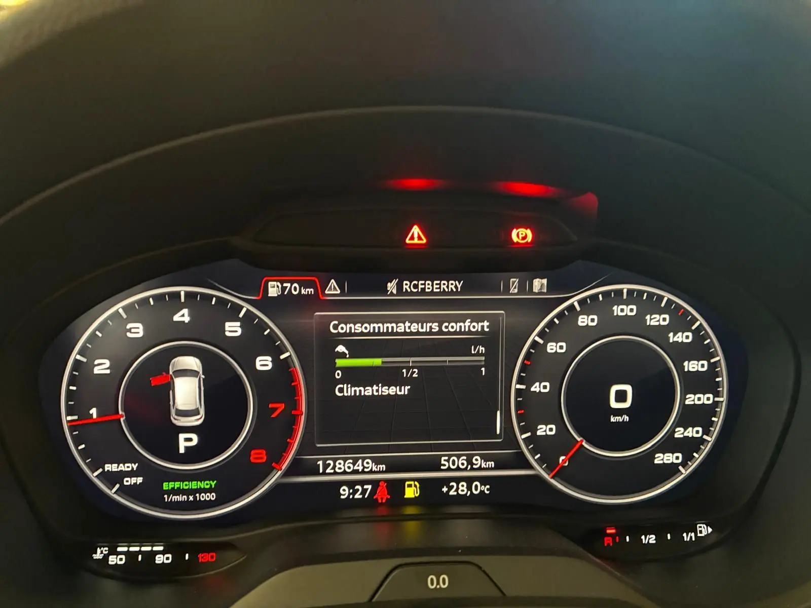 Tableau de bord numérique de l'Audi A3 Sportback blanc, affichant compte-tours, vitesse et consommation, éclairage rouge et blanc.