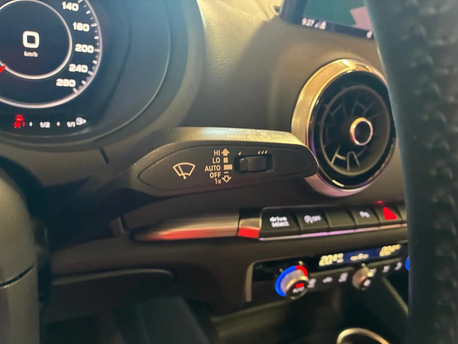 Vue intérieure de l'Audi A3 Sportback 2019, détail du volant, commande d'essuie-glace et aérateur rond chromé.