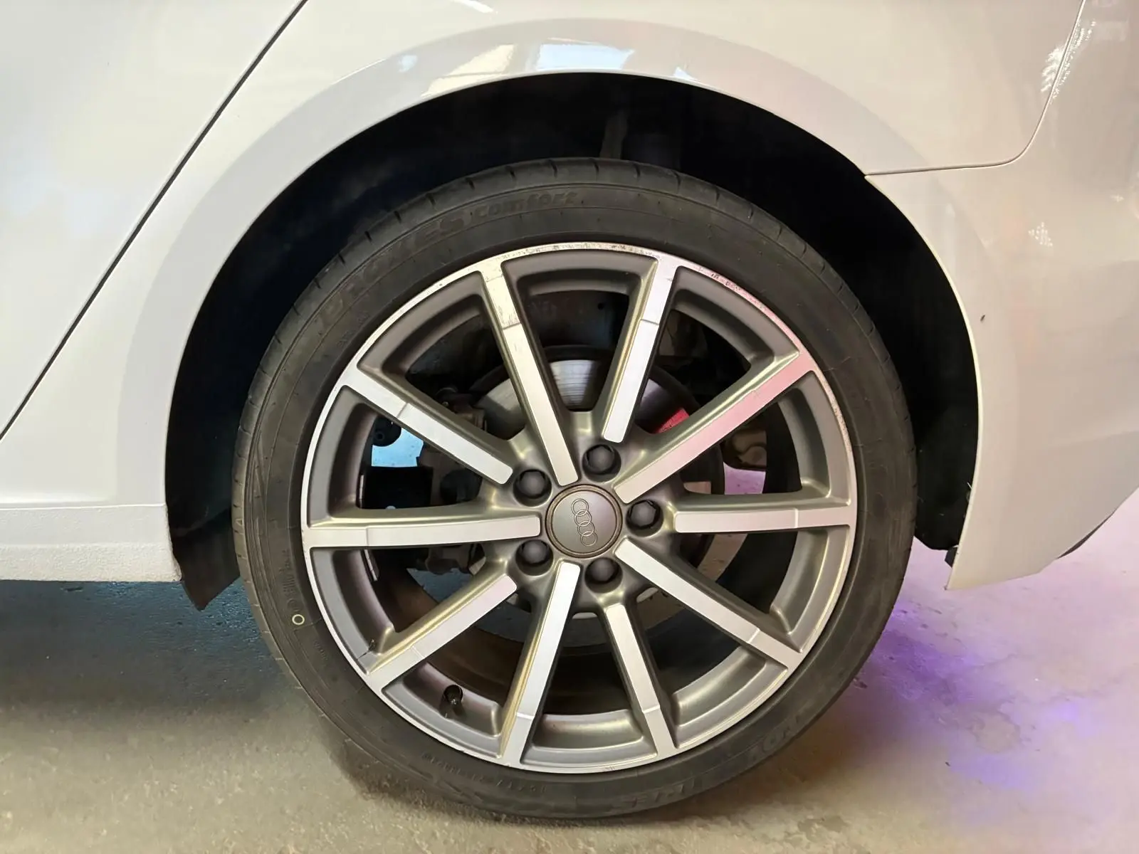 Gros plan sur la roue arrière droite d'une Audi A3 Sportback blanche, mettant en valeur la jante alliage à 10 branches.