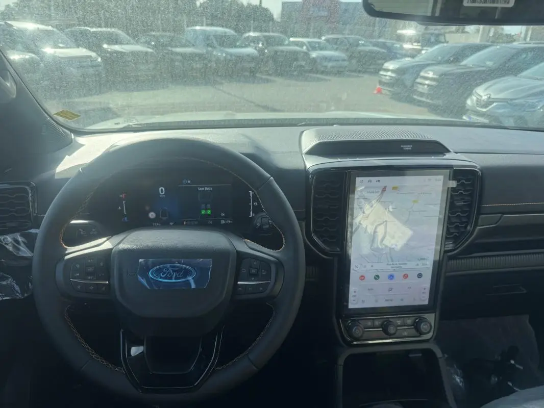 Vue intérieure du tableau de bord du Ford Ranger gris 2025, avec volant multifonctions et grand écran tactile vertical.