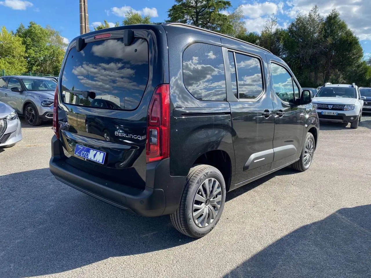 Vue 3/4 arrière droite d’un Citroën Berlingo noir métallisé avec vitres surteintées et hayon arrière vitré.
