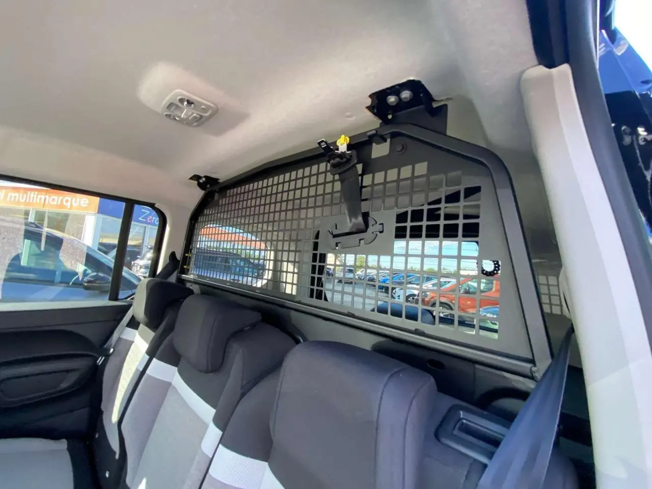 Vue intérieure côté droit du Citroën Berlingo 2026 avec banquette arrière et grille de séparation noire.