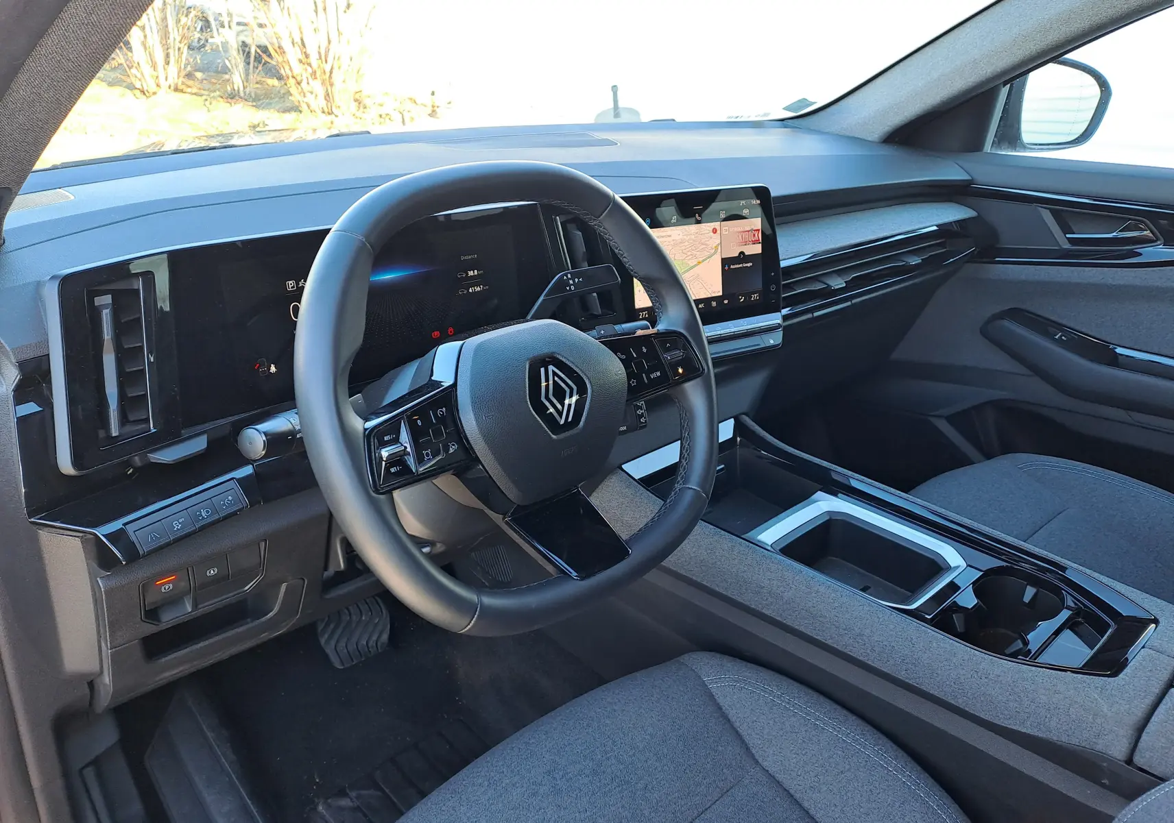 Vue intérieure côté conducteur du Renault Austral 2023, tableau de bord moderne avec écran tactile et volant multifonctions.
