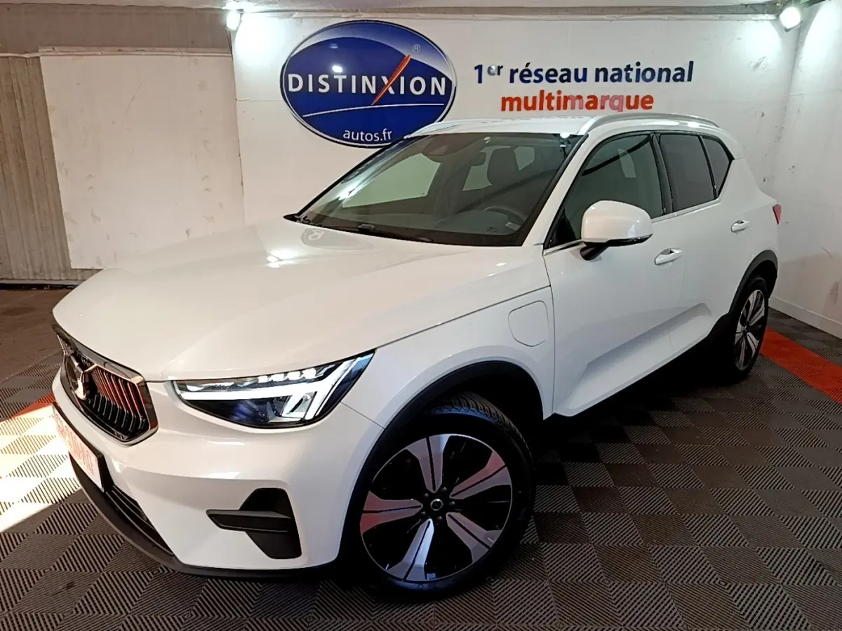 Vue 3/4 avant droit d'un Volvo XC40 hybride rechargeable blanc avec jantes noires et détails chromés.