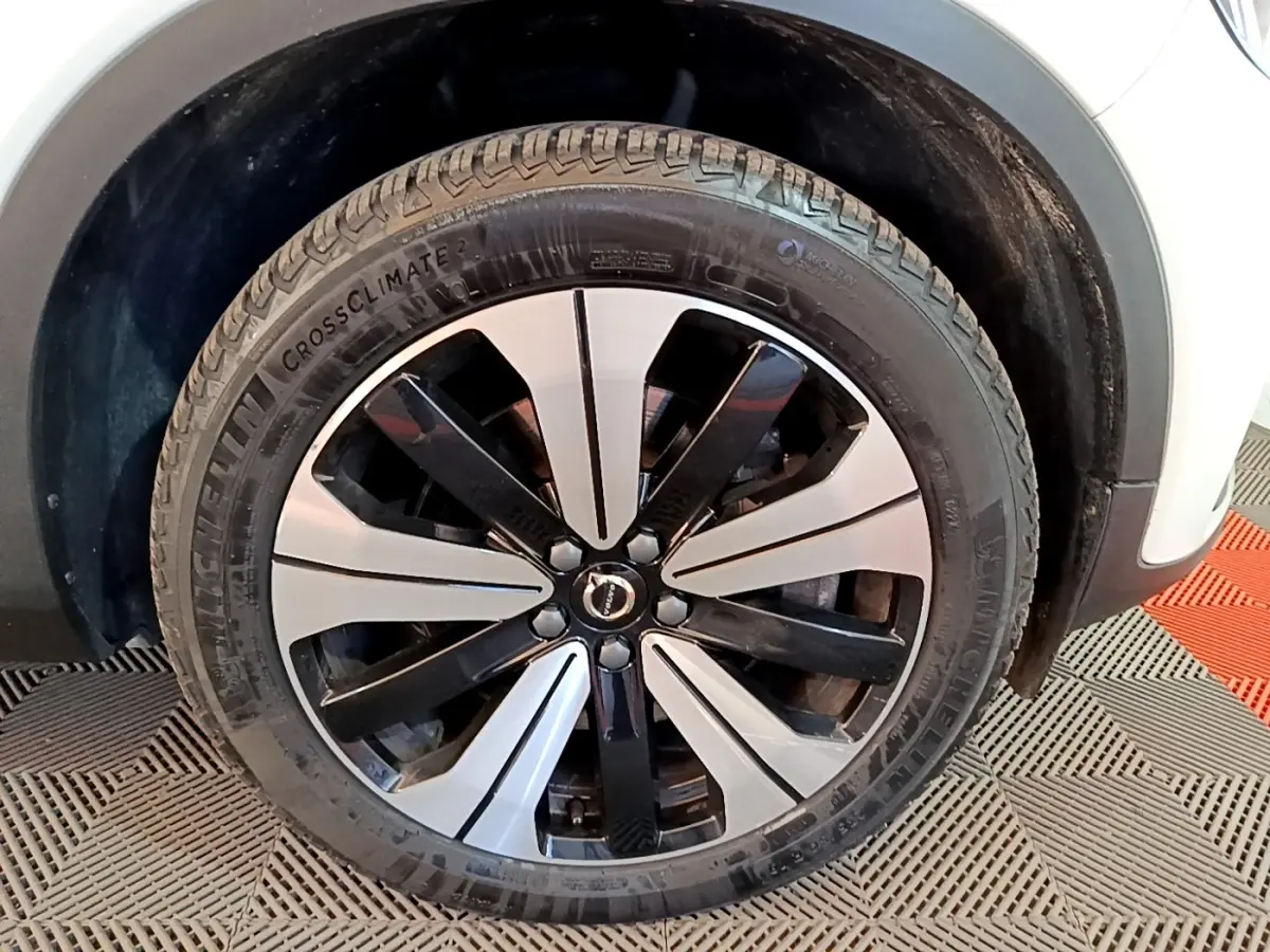 Gros plan sur la roue avant droite du Volvo XC40 Recharge T5 262 DCT7 Plus avec jante bicolore noir et argent