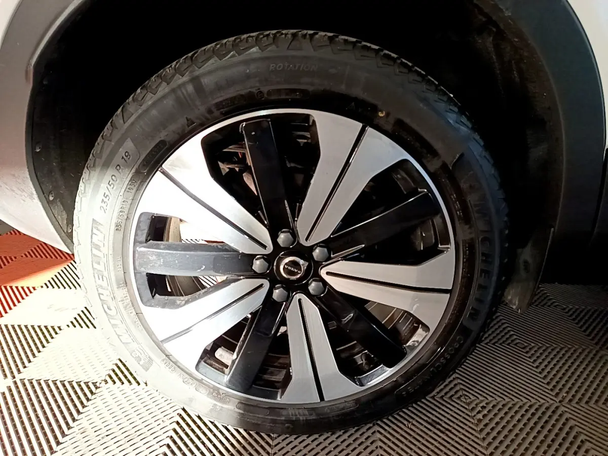 Gros plan sur la roue avant droite du Volvo XC40 Recharge T5 262 DCT7 Plus avec jante bicolore noire et argent.