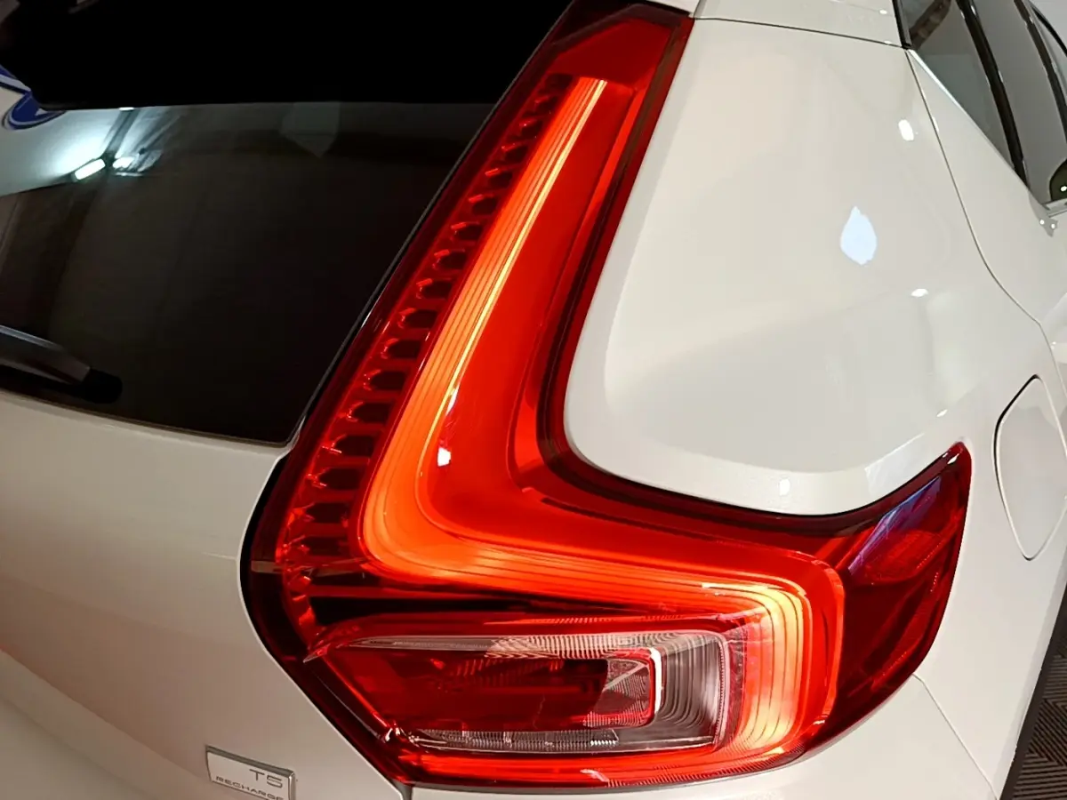 Gros plan sur le feu arrière droit rouge vif du Volvo XC40 Recharge T5 262 DCT7 Plus blanc nacré.