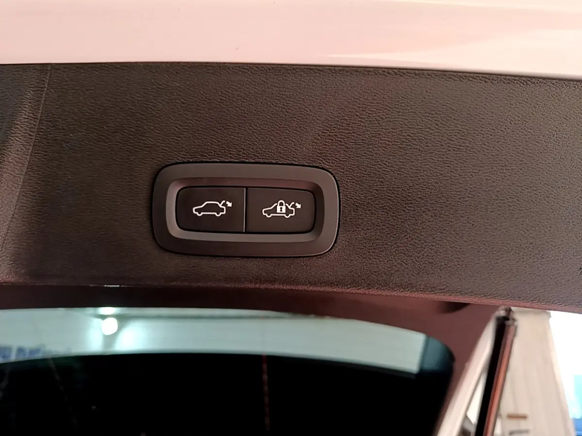 Gros plan sur les boutons de fermeture électrique du coffre du Volvo XC40 Recharge T5 262 DCT7 Plus, intérieur noir.