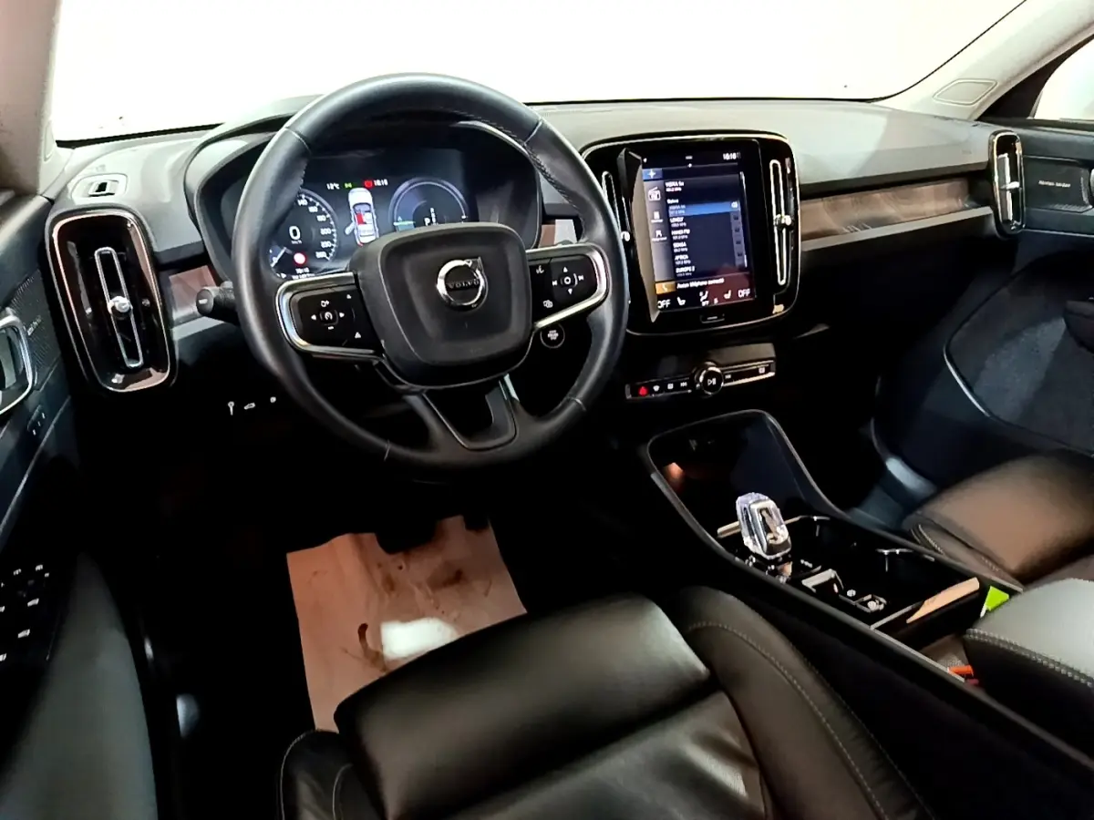 Intérieur noir du Volvo XC40 Recharge T5 2023, vue depuis le siège conducteur sur le tableau de bord et écran tactile central.