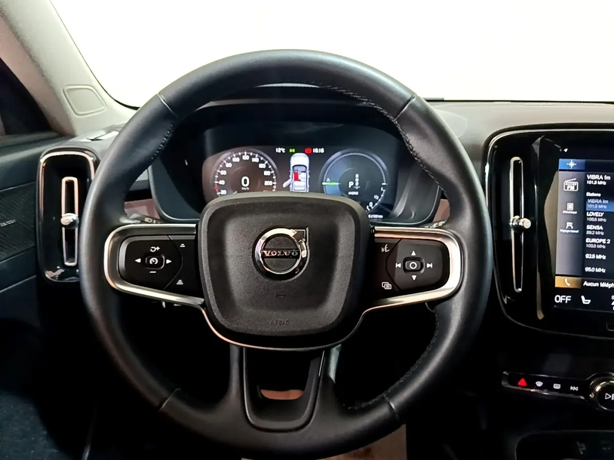 Vue centrée sur le volant noir du Volvo XC40 Recharge T5 2023 avec tableau de bord numérique et écran tactile latéral.