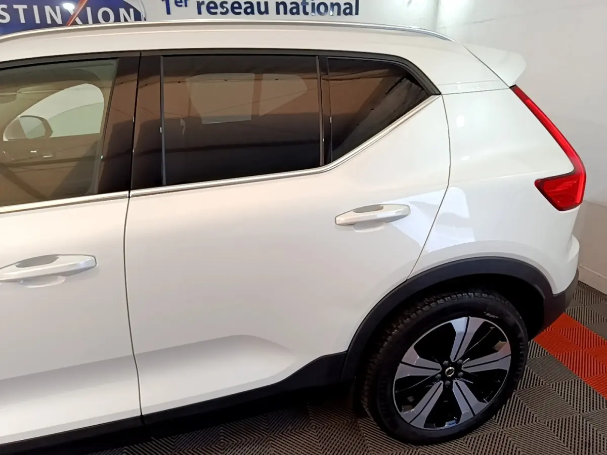 Vue latérale droite d’un Volvo XC40 Recharge T5 blanc avec jantes noires et vitres teintées.