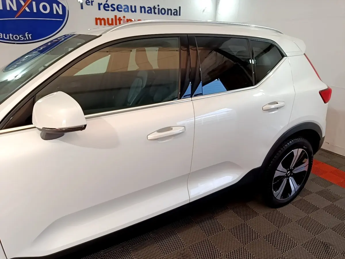 Vue latérale droite d'un Volvo XC40 hybride rechargeable blanc avec jantes noires et détails chromés.