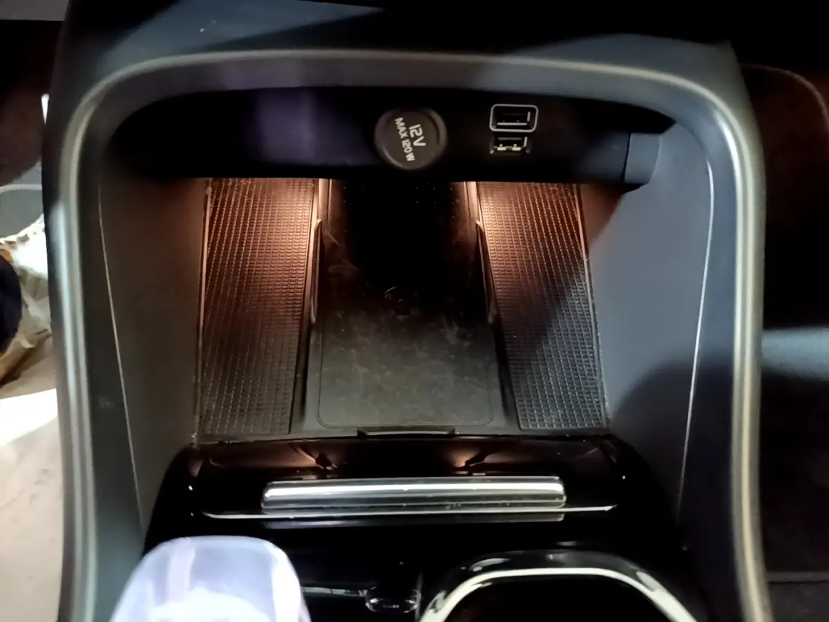 Vue plongeante sur la console centrale noire du Volvo XC40 Recharge T5 avec prise 12V et port USB visibles.