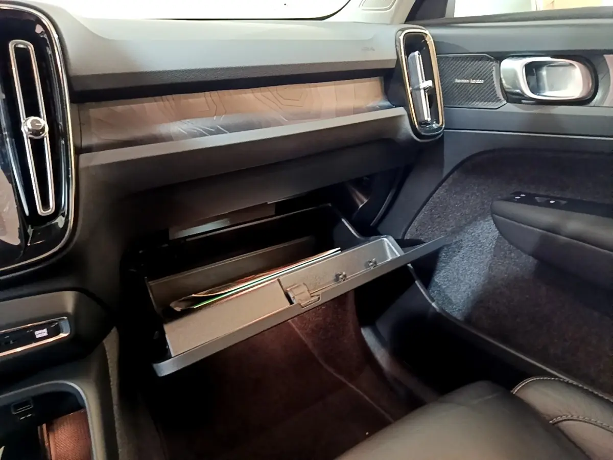 Vue intérieure côté passager du tableau de bord noir et boîte à gants ouverte du Volvo XC40 Recharge T5 2023.