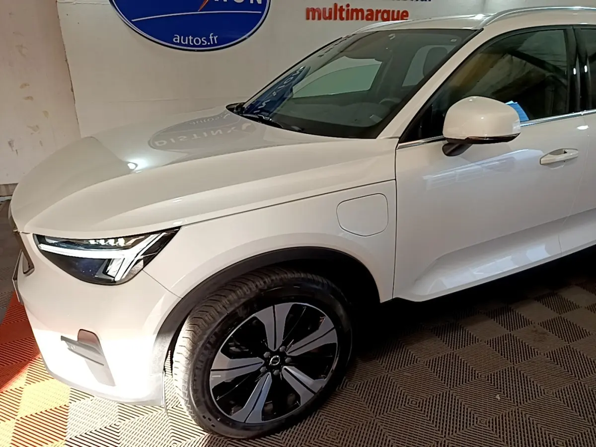 Vue 3/4 avant droit d'un Volvo XC40 hybride rechargeable blanc avec jantes noires et détails modernes.