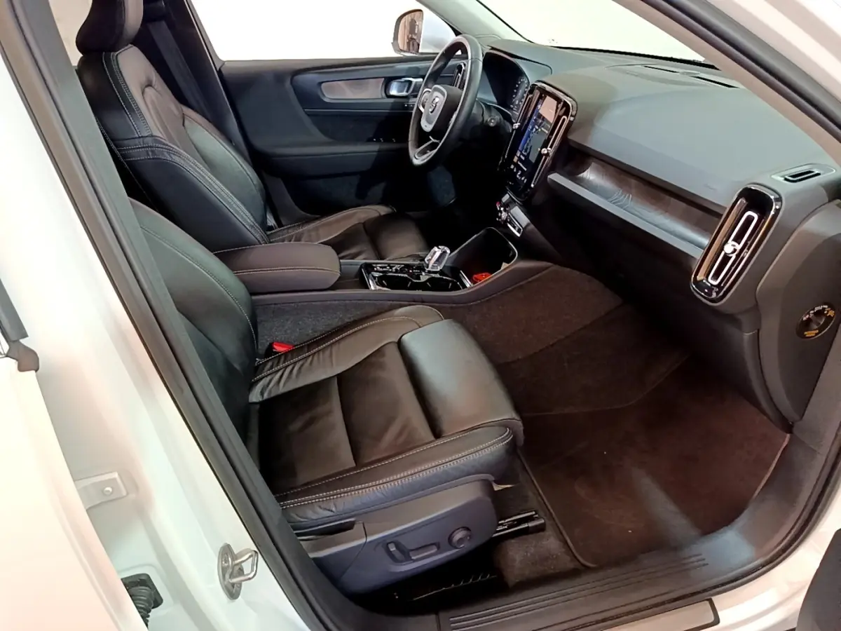 Intérieur noir cuir du Volvo XC40 Recharge T5 2023 vu côté conducteur, avec tableau de bord tactile et volant multifonctions.