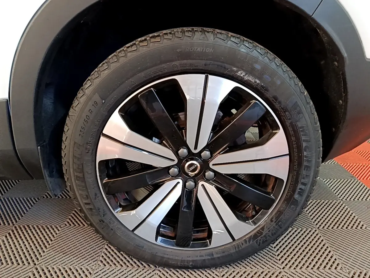 Gros plan sur la roue avant gauche du Volvo XC40 hybride rechargeable, jante alliage bicolore noir et argent.