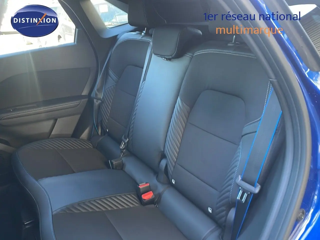 Vue intérieure montrant la banquette arrière en cuir noir avec surpiqûres bleues du Renault Symbioz bleu Iron Metal.